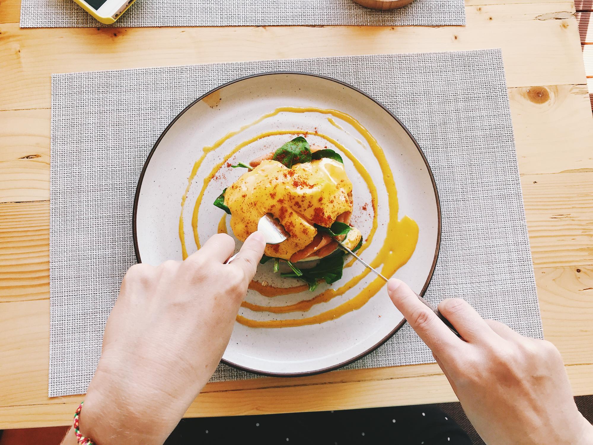 Hands plating a modern dish in editorial style